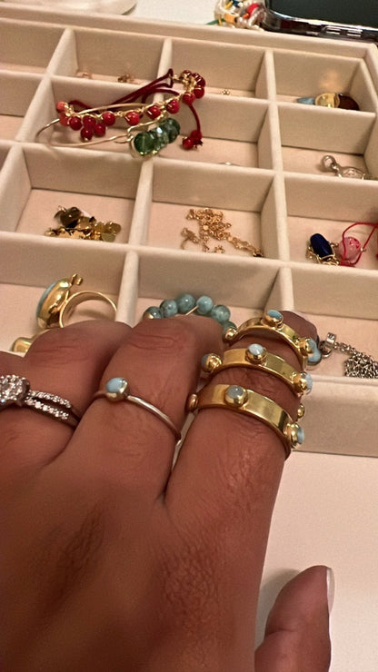 Woman modeling 3 larimar open rings on her index finger. close up