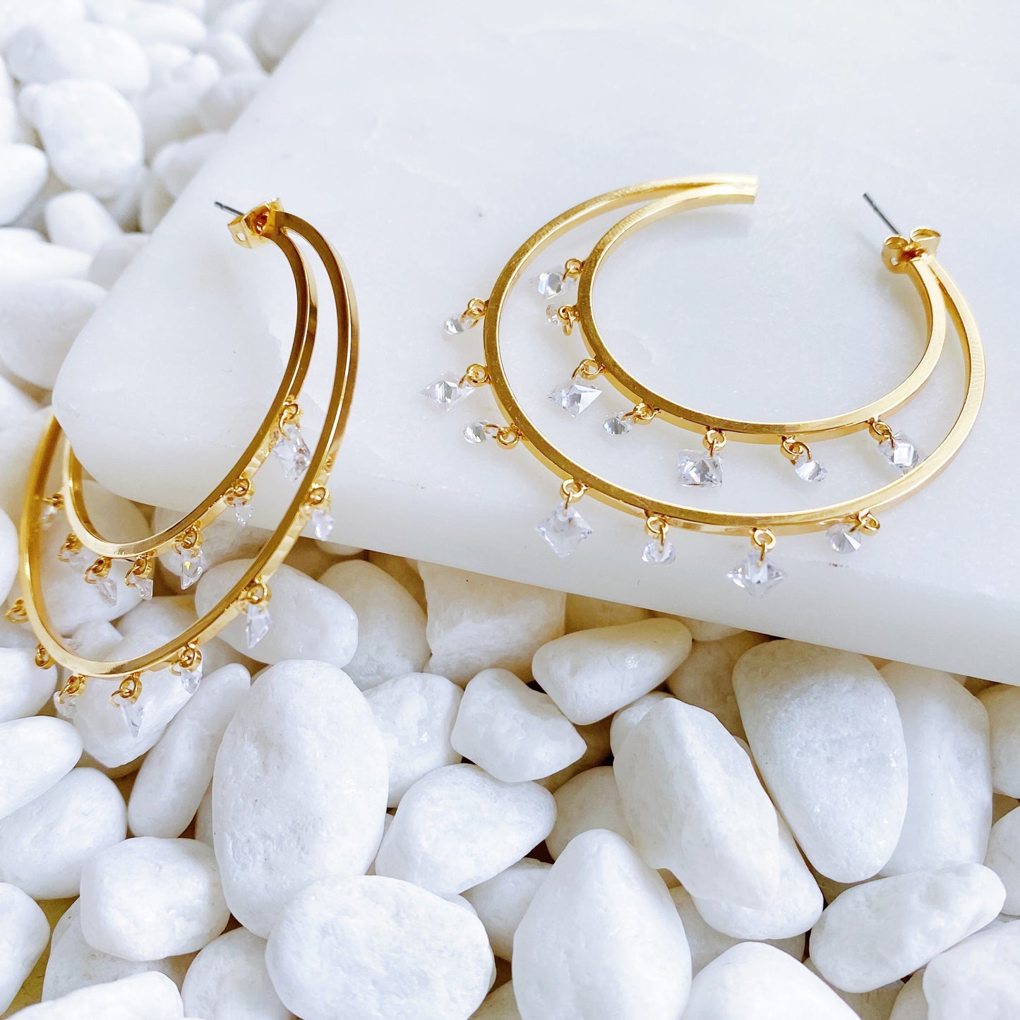 golden, double-hooped earrings, adorned with beautiful natural crystals hanging from them